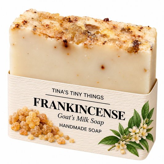 Tina's Tiny Things Frankincense Handmade Goat's Milk Soap Bar featuring a creamy ivory-colored body, rustic textured top with golden amber accents, and elegant packaging decorated with frankincense resin and botanical illustrations.