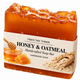 Tina's Tiny Things Honey & Oatmeal Handmade Soap Bar featuring golden amber-colored artisan soap with a honeycomb-textured top and decorative packaging illustrated with honey, honeycomb, and rolled oats.
