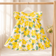 Yellow floral dress hanging on a wooden rack with a light background