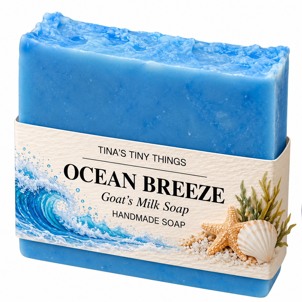 Tina's Tiny Things Ocean Breeze Handmade Goat's Milk Soap Bar featuring vibrant ocean-blue coloring, a textured wave-inspired top, and decorative coastal packaging with ocean waves, seashells, and starfish.
