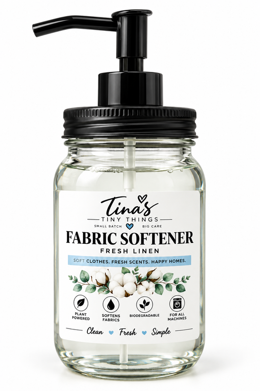 Tina's Tiny Things Fresh Linen Liquid Fabric Softener in a clear glass mason jar with black pump dispenser, featuring a white label with cotton flowers, eucalyptus leaves, and blue accents against a clean white background.